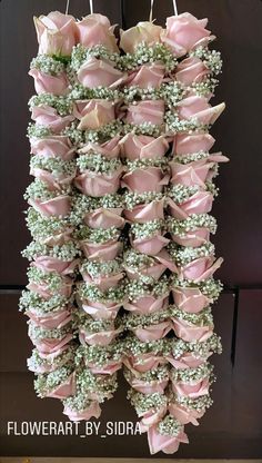 pink and white flowers hanging from clothes pins