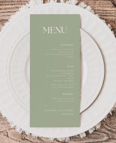 a white plate topped with a menu on top of a wooden table