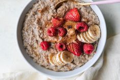 a bowl of oatmeal topped with sliced bananas and strawberries