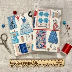 sewing supplies and thread laid out on a piece of fabric with scissors, spools of thread next to it