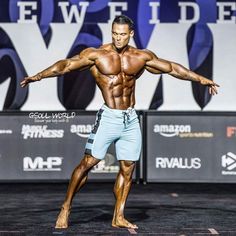 a man standing on top of a stage with his arms spread out in front of him