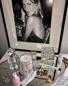 an image of a woman in black and white on the wall above a table with candles