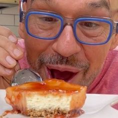 a man with glasses eating a piece of cheesecake