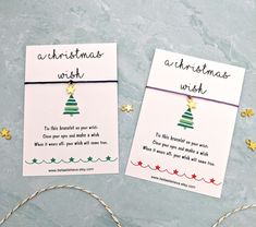 two christmas wish cards sitting on top of a table