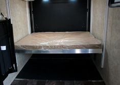 the inside of an rv with a bed and storage area on each side of the door