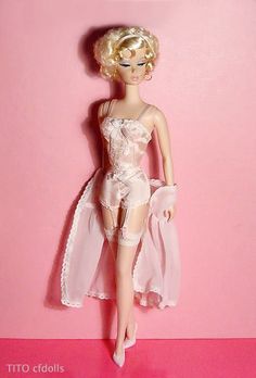 a barbie doll is posed on a pink background