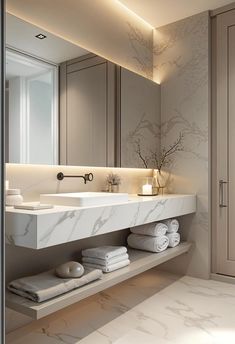 a bathroom with marble counter tops and white towels on the shelf next to the sink