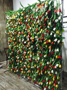 a wall covered in lots of different colored flowers