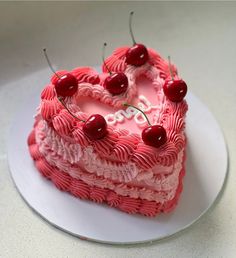 a heart shaped cake with cherries on top