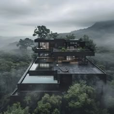 an aerial view of a house in the middle of some trees and foggy mountains