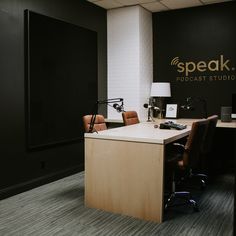 an office cubicle with desk, chair and lamp in front of the sign that says speak