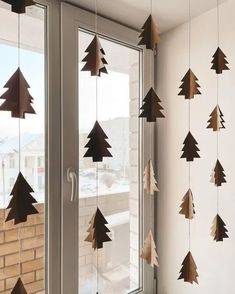 wooden christmas trees hanging from the side of a window