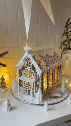 a gingerbread house is lit up with christmas lights