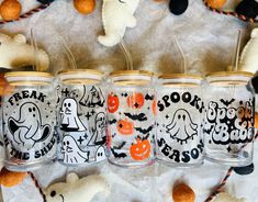 four halloween mason jars with pumpkins and ghost on them