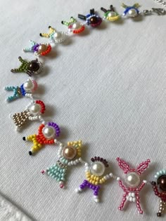 the beaded necklace is decorated with colorful beads and bows on white linens,