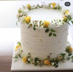 a white cake with yellow and white flowers on it