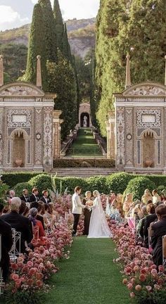 a wedding ceremony in front of an elaborate garden