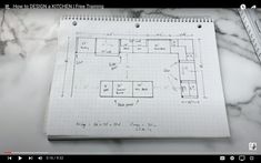 an open notebook with a drawing on it and a ruler next to it that says how to design a kitchen floor plan