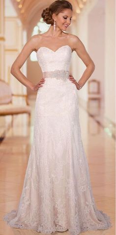 a woman in a wedding dress posing for the camera with her hands on her hips