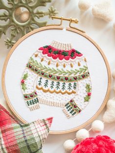 a cross stitch christmas ornament on a white background with red and green ornaments