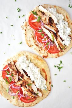 two pita breads with chicken, tomatoes and onions