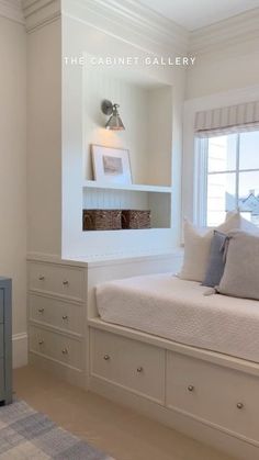 a bedroom with white walls, drawers and a bed in the corner next to a window