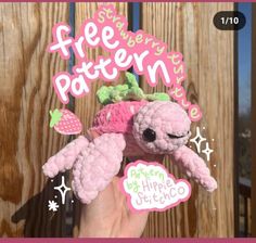 a hand holding a pink stuffed animal with the words free pattern on it and a strawberry