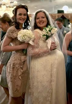 two women in wedding dresses hugging each other