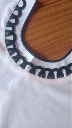 a close up of a white shirt with black circles on the front and back side