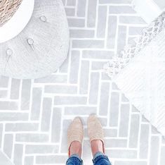 a person standing on a tile floor with their feet up in front of the camera