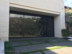 an image of a modern garage with grass in the front yard