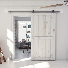 an open door leading to a living room with chairs and bookshelves in it