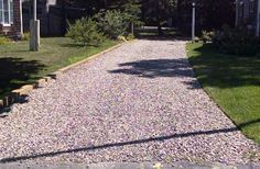 a gravel road with benches on the side