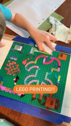 a young boy is making a lego art project