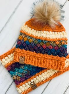 a multicolored knitted hat with a pom - pom on top