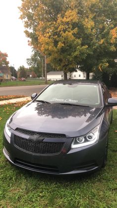 a black car is parked in the grass