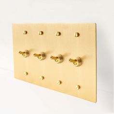 a gold wall mounted coat rack with six knobs