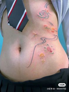 a woman with tattoos on her stomach has a tie around her waist