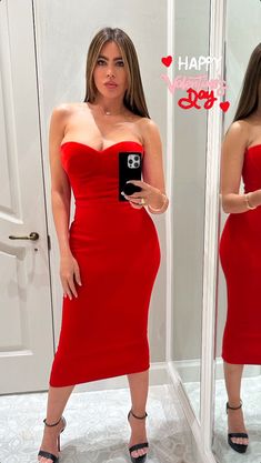 a woman in a red dress taking a selfie with her cell phone and looking into the mirror