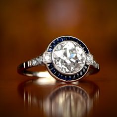 a diamond and blue sapphire ring on a table