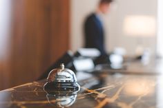 a bell sitting on top of a counter next to a man in a suit and tie