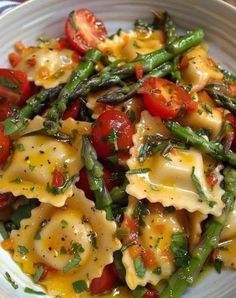 a white plate topped with pasta and veggies covered in cheese sauce on top of a blue checkered table cloth