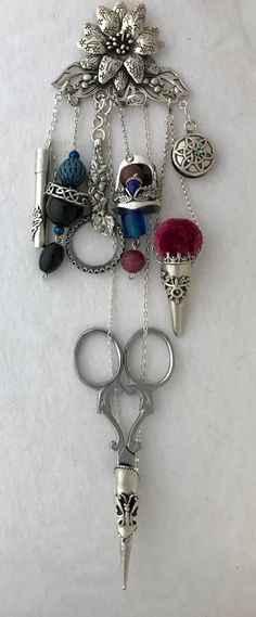 a bunch of different items hanging on a white wall in the shape of a keychain