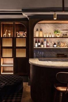 a bar with stools and shelves filled with bottles