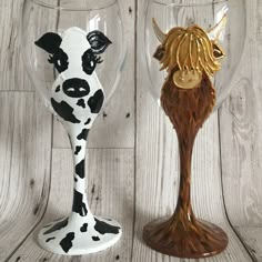 two glass goblets with cows painted on them, one is brown and the other is white