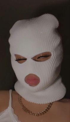 a woman wearing a white mask and choker