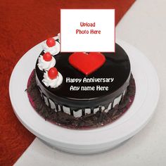 a black and white cake on a plate with a sign that says happy anniversary any name here