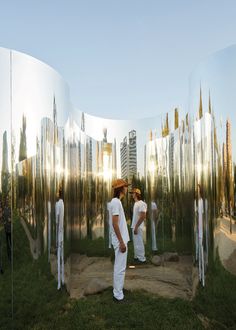 two men are standing in front of mirrored mirrors that look like they're looking at each other