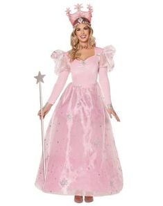 a woman in a pink dress and tiara is holding a wand with stars on it