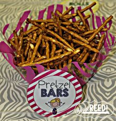 pretzel bars in a pink box on a zebra print tablecloth with a sticker that says pretzel bars